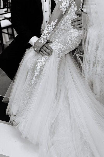 Close up Black and white photo of groom with arms around bride