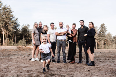 Familieshoot opa oma kinderen en kleinkinderen in sevenum op de zandvlakte meisje rent naar camera toe