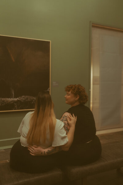 LGBTQ couple admiring art at art museum during their engagement session in Ocean Springs.