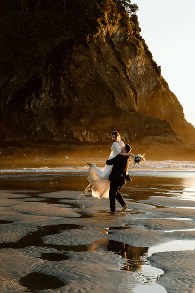 Bride holding up a bouquet of flowers during a beach elopement in Michigan.