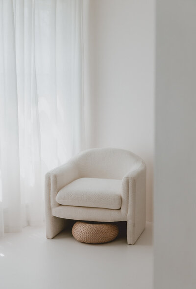 girl sitting relaxed on white stool in photo studio