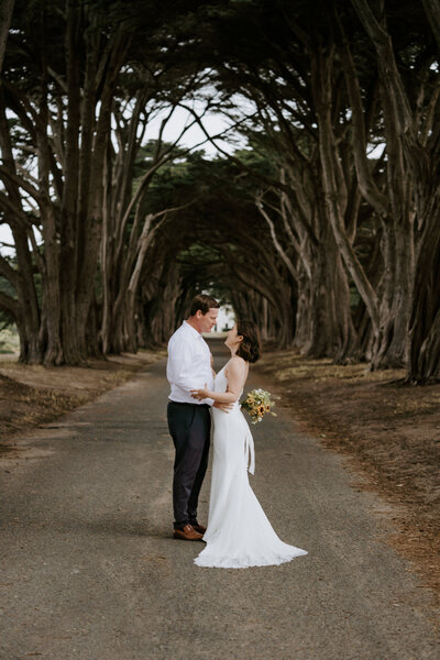 bride and groom embracing on path