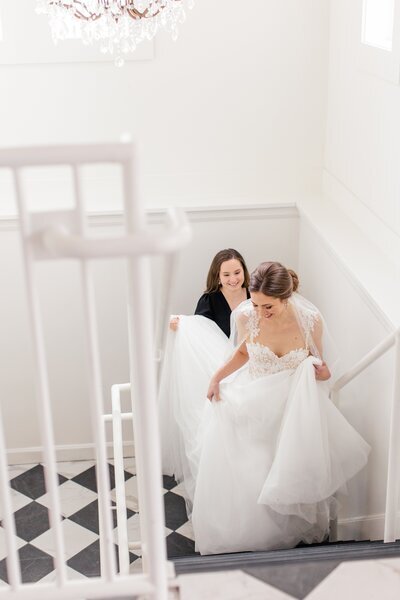Bride walking up the stairs with help from her day-of wedding coordinator in Michigan.