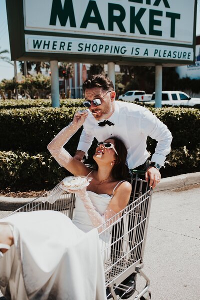 Bride feeding groom key lime pie while sitting in a shopping car in a vintage Publix during their vintage Orlando elopement