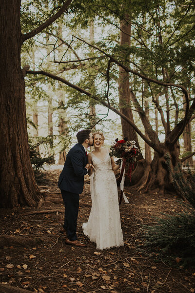 Bride and Groom kiss in woods