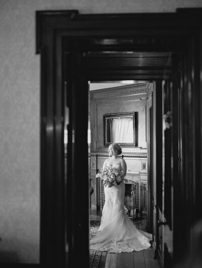 Bride poses in the library room at the Felt Mansion for pictures at her summer wedding in Holland