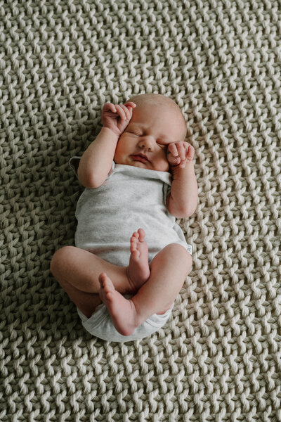 Newborn baby girl sleeping on blanket in lifestyle studio in Annapolis Maryland.