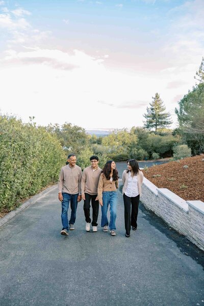 family walking on a driveway with a beautiful sunset in the background