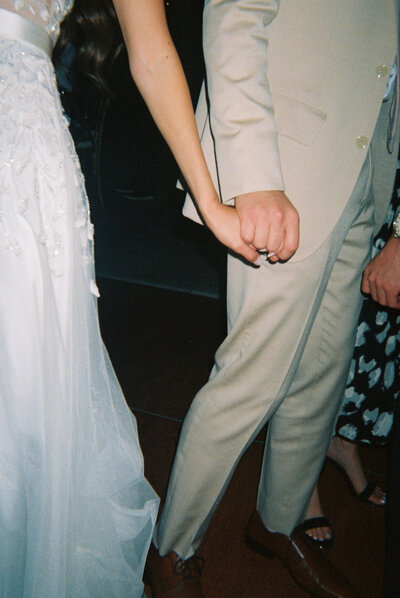 Film photo of bride and groom's hands holding each other