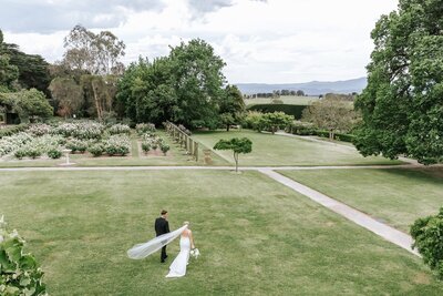 Bride in a white wedding dress holding a bouquet of light peach flowers