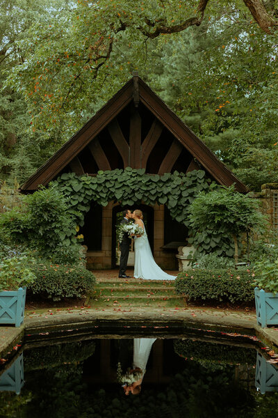 bride and groom kissing by pond