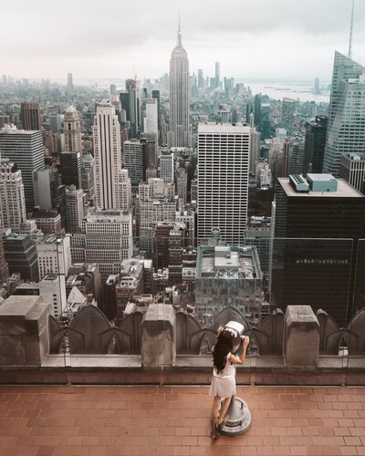 Woman at lookout on a rooftop overlooking New York City