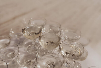 A close-up of candlelit clear glass votive holders on a reflective surface.