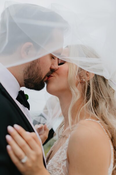 wedding couple kissing under veil