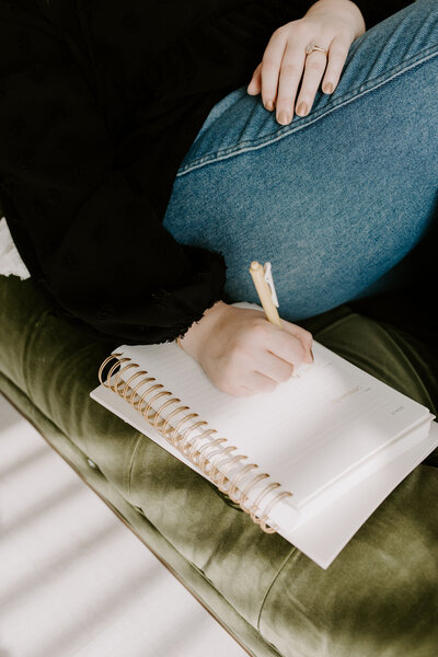 Therapist writing in notebook on couch
