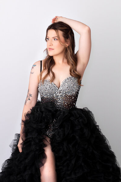 A woman is standing posed in a gown  with diamonds at a boudoir and beauty photographer studio in Asheville North Carolina