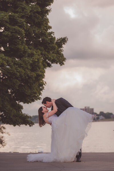 Wedding photo of couple kissing by the water, taken by a wedding photographer in Michigan