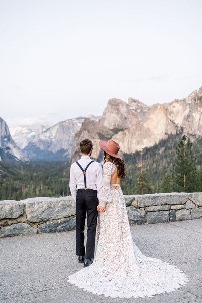 A bride and groom look at Yosemite Valley during their elopement