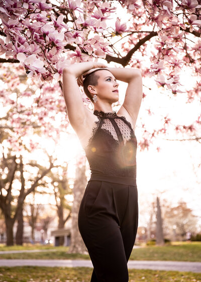 female in black jumpsuit posing with spring blooms