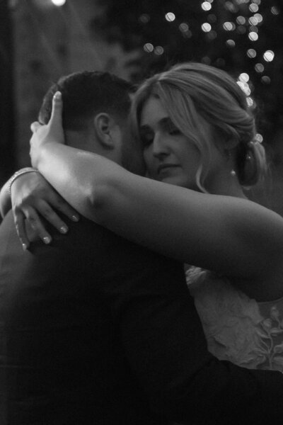 black and white photo of bride and groom hugging