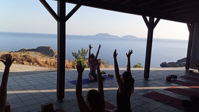 A tranquil retreat atmosphere with guests relaxing and practicing yoga outdoors.