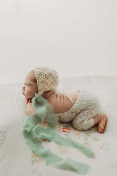 profile shot of baby girl with a knit bonnet sleeping