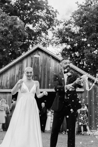 groom popping champagne bottle