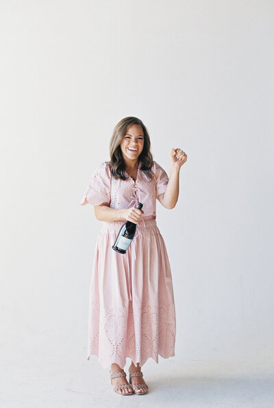 Claire Hodges popping a bottle of champagne