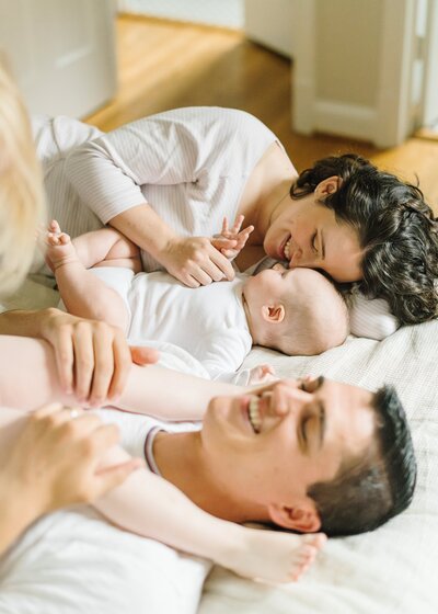 Parents with 4 children sitting and snuggling around a wooden table - Northern Virginia family photographer