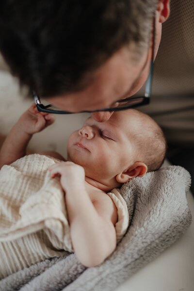 Vater küsst Baby auf die Stirn