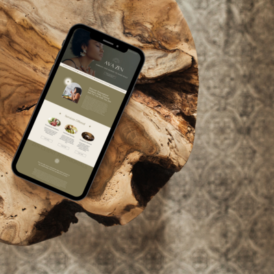 iPhone displaying Ava Zen wellness website on a rustic wooden table, showcasing holistic branding for wellness entrepreneurs