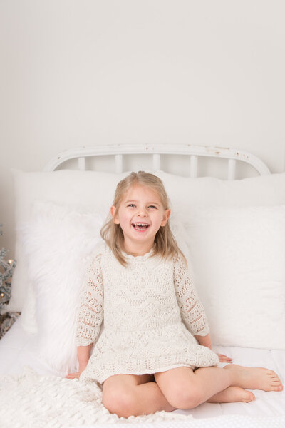 Baby girl wrapped in blush on white bed