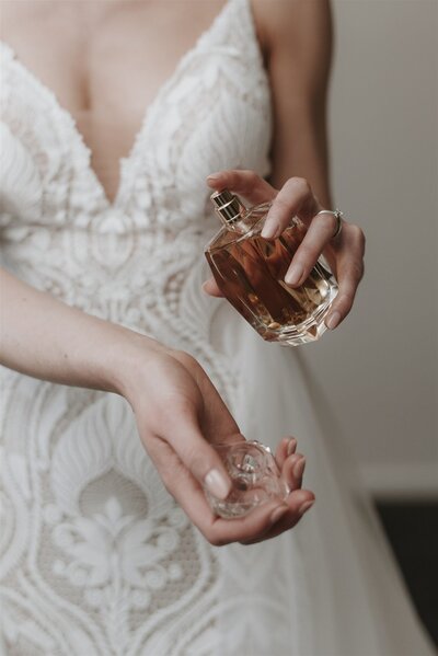 Elegant bride applying perfume before her wedding day, planned by a luxury wedding coordinator in Raleigh.