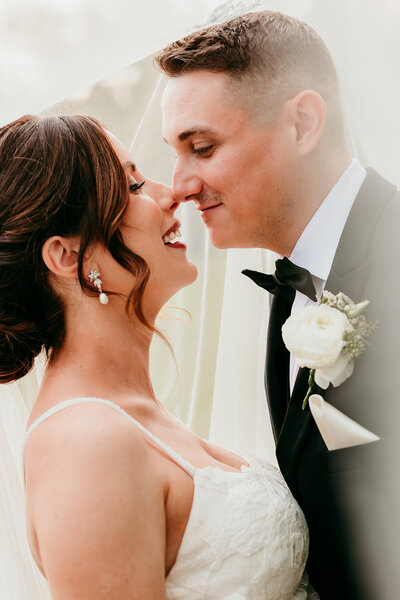 Documentary style NJ wedding photography of bride and groom looking at each other with noses touching