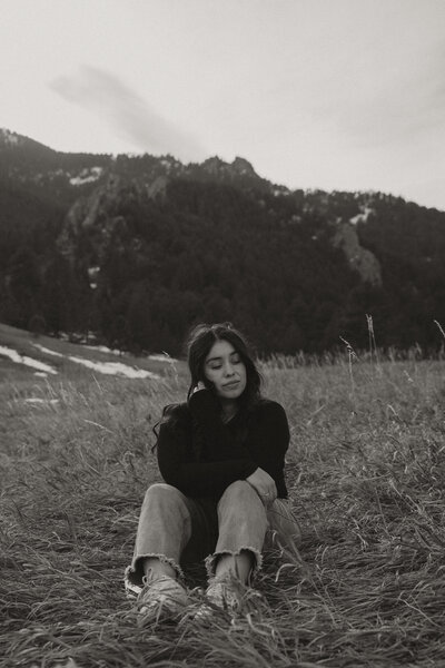 photographer sitting in field, boulder mountain