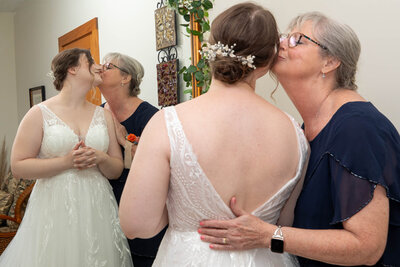 Katie being kissed by her other in front of the r mirror during getting ready