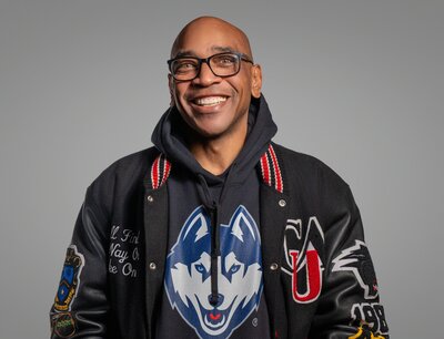 A person with glasses smiling big 