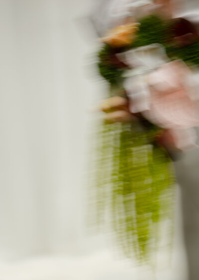 Bride holding bouquet with soft natural light in a Charleston park.