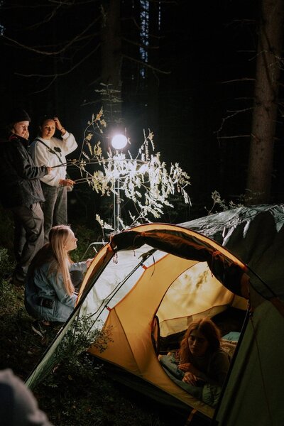 young people filming inside nature a girl in a tent