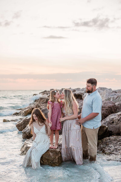Family sits on rocks during photo shoot at Upham Beach