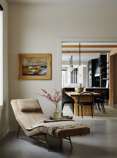 Mountain House project vignette of chaise and peek into the dining room with black chairs.