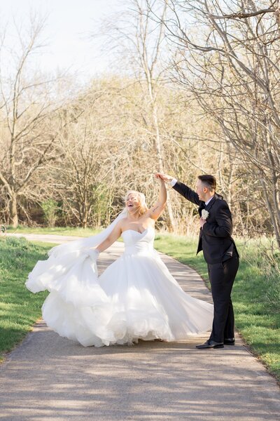 Groom spinning bride with a sweeping train and veil at a misty golf course in Green Bay, WI