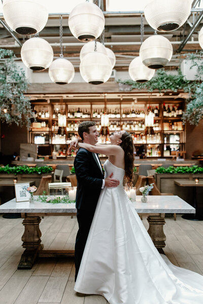 Bride and groom spray champagne on the rooftop of The Drake after dark