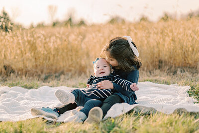 Young girl hugging her mom in a field of yellow grass