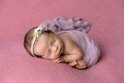 newborn girl smiles dressed in pink
