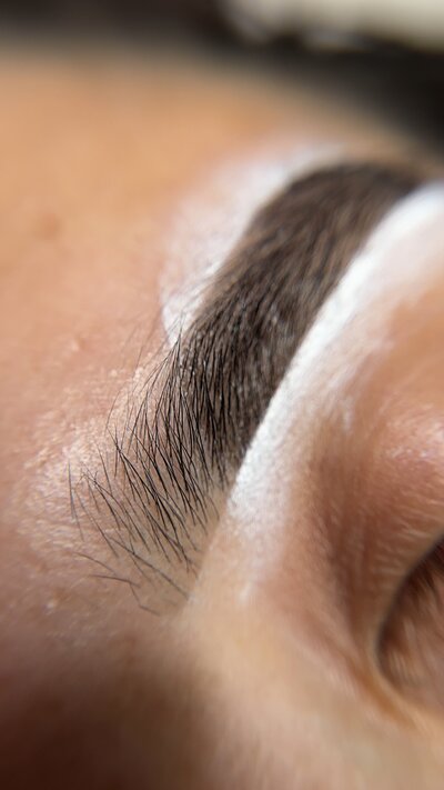 up close of brow tinting and brow shaping. brows are sketched to ensure precision and clean finish.