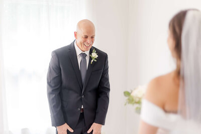 Dad smiles joyfully during first look with bride at destination wedding captured by Destination Wedding Photographer.