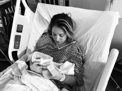 bereaved mother holds twin stillborn babies in knit crochet cradles
