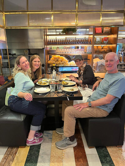 Maria Cristina and a group of 3 guests sitting in a booth at a restaurant during their Tapas and Wine Experience.