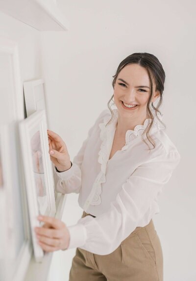 San francisco maternity photographer Laurel Smith holding up prints in her studio